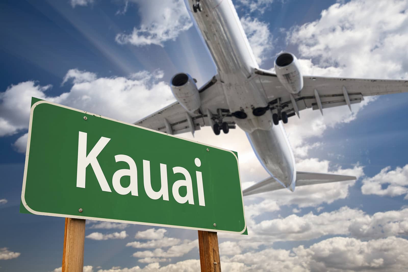 Kauai Green Road Sign and Airplane Above with Dramatic Blue Sky and Clouds