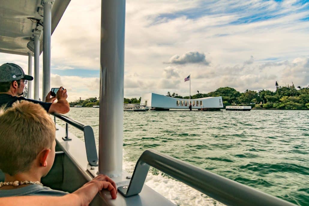 People on Boat with USS Arizona Memorial in background  