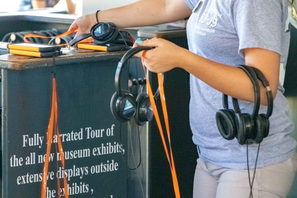 Pearl Harbor Audio Tours Girl with Headsets at Desk Oahu